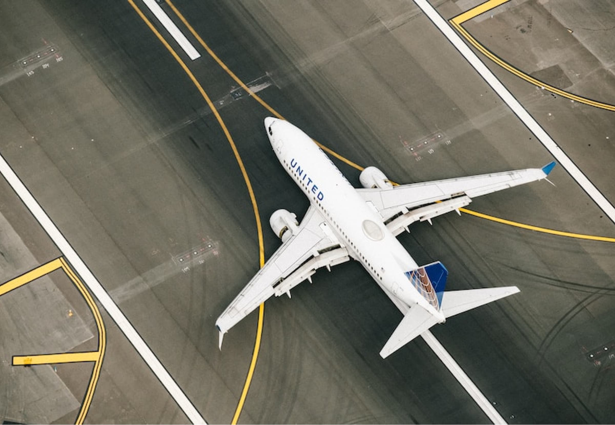 an aerial view of an airplane on the runway.