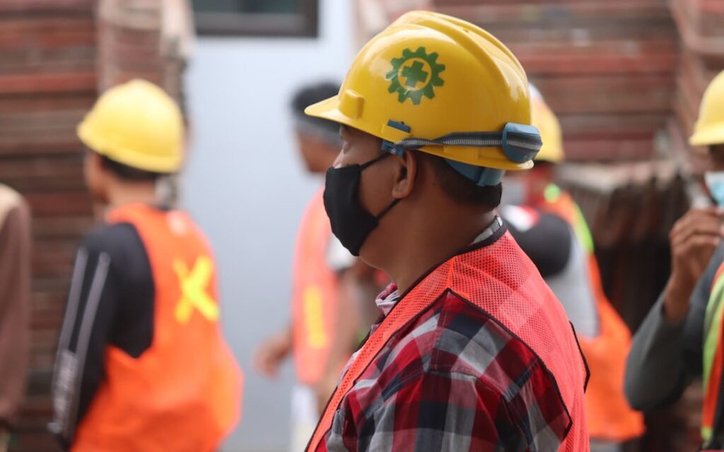 a group of construction workers wearing face masks.